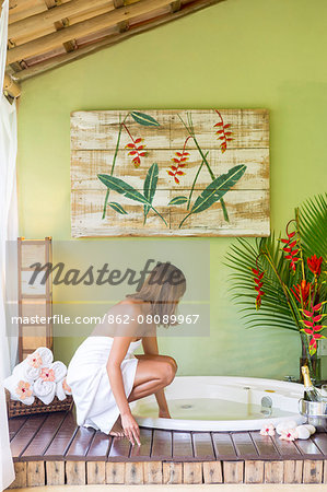 South America, Brazil, Bahia, Trancoso, a young woman standing next to a spa bath in the Mata Nativa Pousada, (MR) (PR)