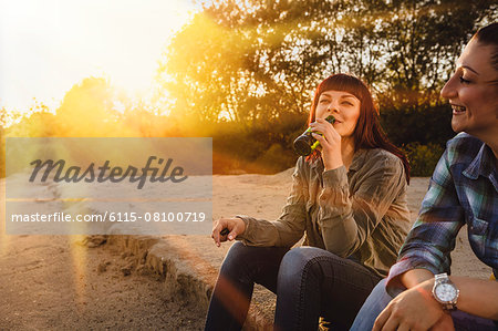 Two women drinking beer on a riverbank, Osijek, Croatia