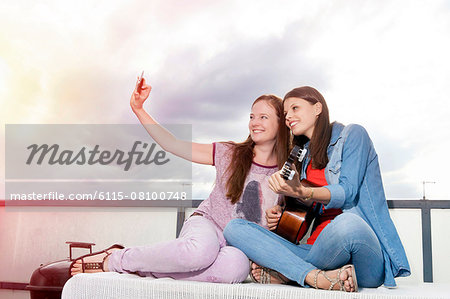 Two young women taking self portrait with smart phone, Munich, Bavaria, Germany