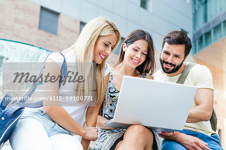 Three students using laptop together