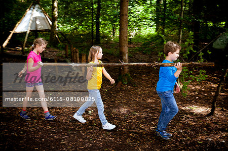 Children carrying wood in a forest camp, Munich, Bavaria, Germany