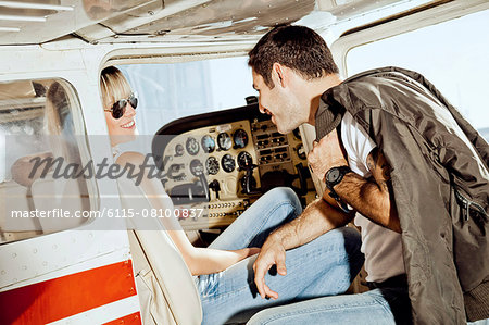 Young couple preparing  for start in private airplane