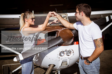 Young couple preparing for start in propeller airplane