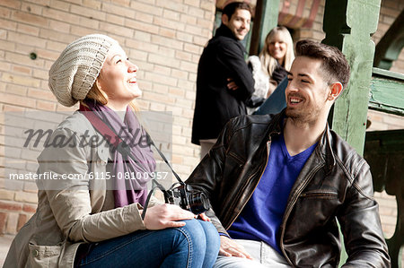 Happy young couple, friends in background