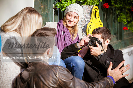 Man taking a picture of friends outdoors