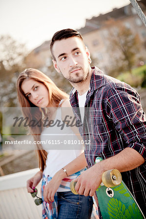 Portrait of young couple with skateboard