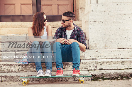 Young couple with skateboard taking a break