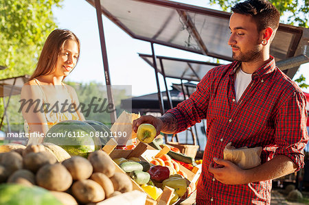 Male customer buying vegetables at market stall