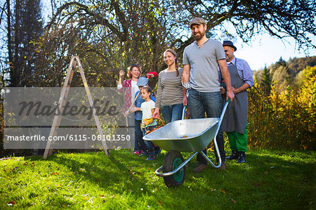 Family with wheelbarrow in garden, Munich, Bavaria, Germany