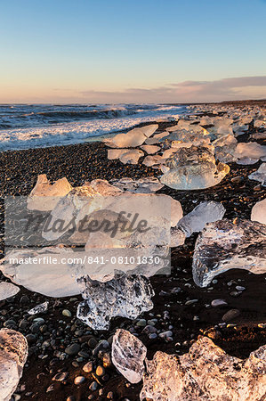 Broken ice from washed upiIcebergs on Jokulsarlon black beach at sunrise, Jokulsarlon, south east Iceland, Iceland, Polar Regions