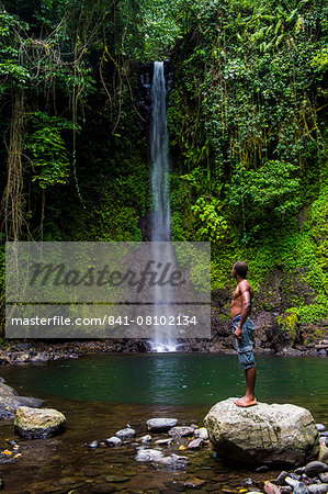 Man looking at the waterfall cascade Bombaim in the jungle interior of Sao Tome, Sao Tome and Principe, Atlantic Ocean, Africa