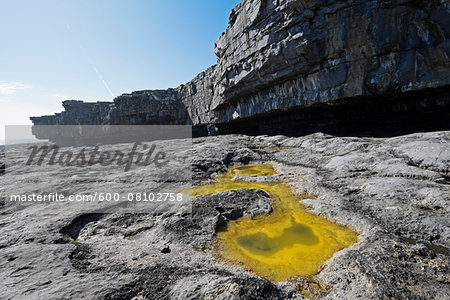 Coastal cliffs with tidal pool on rocky shoreline, Aran Islands, Republic of Ireland