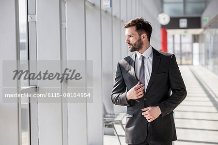 Businessman adjusting tie in airport