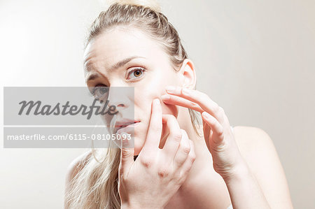 Young woman examining face