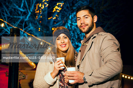 Young couple drinks punch at Christmas Market