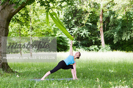 Young woman does stretching exercises with rubber band, Munich, Bavaria, Germany