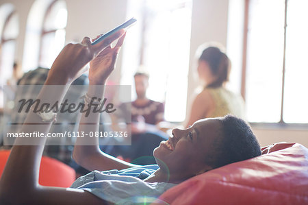 Smiling casual businesswoman using digital tablet in bean bag chair