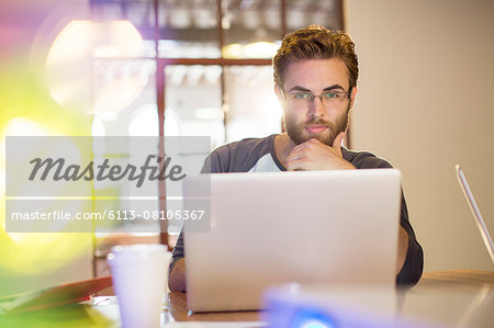 Focused casual businessman working at laptop in office