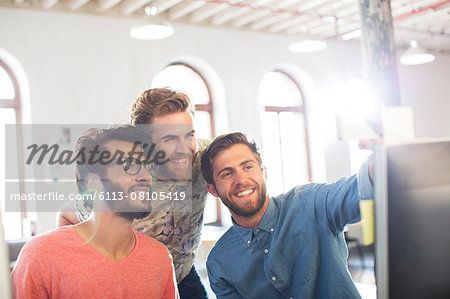 Smiling casual businessmen working at computer in office