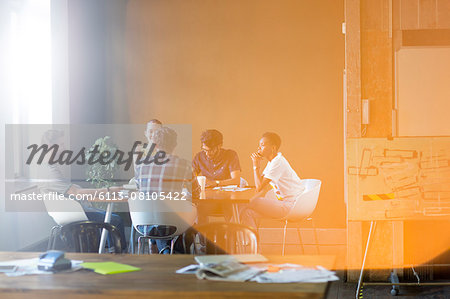 Lens flare over creative business people meeting at office table Lens flare over creative business people meeting at office table