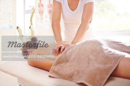 Woman receiving massage by masseuse