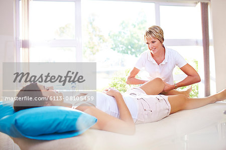 Masseuse massaging woman's leg