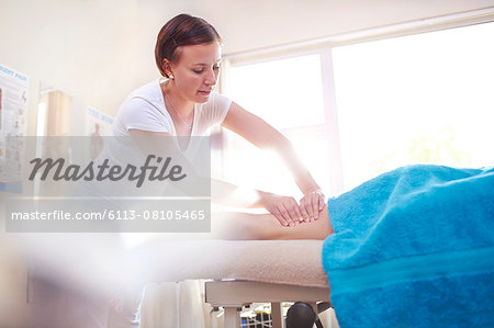 Masseuse massaging woman's leg Masseuse massaging woman's leg