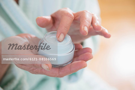 Senior woman applying moisturizer, Munich, Bavaria, Germany Senior woman applying moisturizer, Munich, Bavaria, Germany