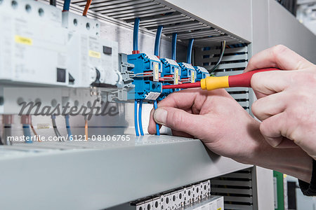 Close-up of electrician screwing cable in distribution fusebox, Munich, Bavaria, Germany