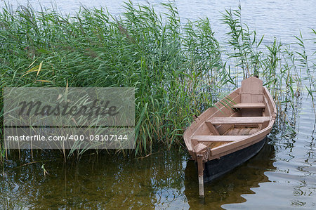 wooden boat over the riverside of lake