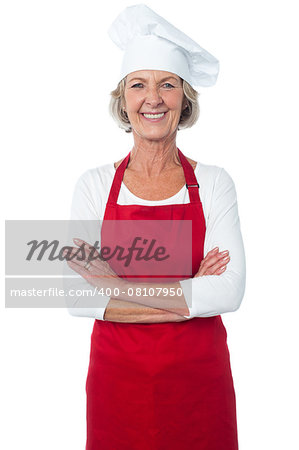 Confident aged woman chef smiling, arms crossed