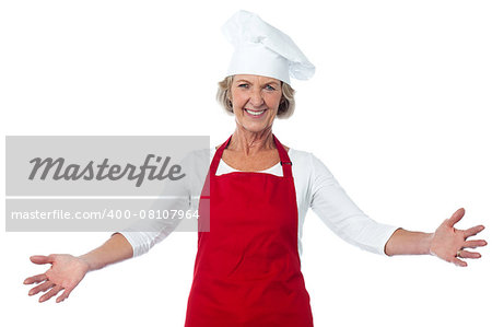 Smiling joyous aged female chef with open arms