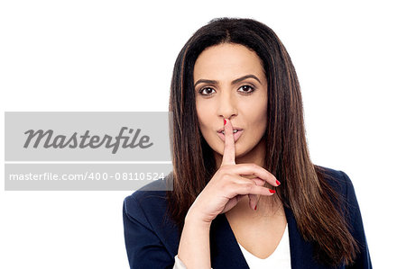 Beautiful businesswoman with finger on lips, shhh!!