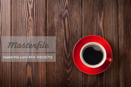 Coffee cup on wooden table background. Top view with copy space