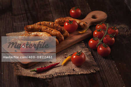 Grilled sausage with fresh herbs on wodden table