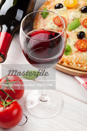 Pizza and red wine on wooden table background