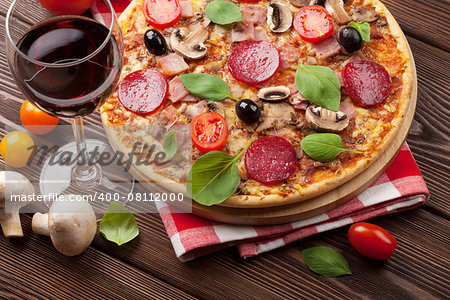 Pizza and red wine on wooden table background. Top view