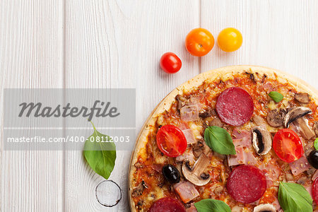 Italian pizza with pepperoni on wooden table. Top view with copy space