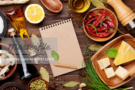Various spices on wooden background. Top view with notepad for copy space