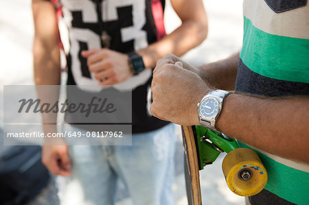 Cropped shot of father and son skateboarders on sidewalk, Copacabana, Rio De Janeiro, Brazil