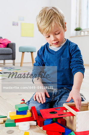 Boy playing with building blocks at home