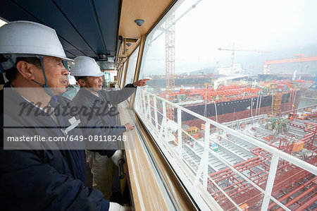 Workers having discussion overlooking shipping port, GoSeong-gun, South Korea