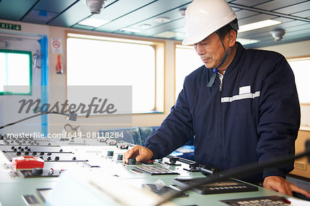 Worker using equipment at shipping port, GoSeong-gun, South Korea Worker using equipment at shipping port, GoSeong-gun, South Korea