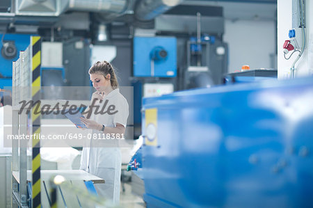 Woman working at machinery in laundry