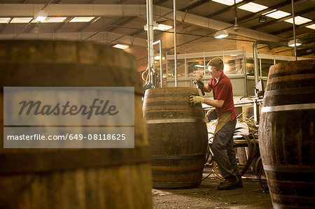 Young man making whisky cask in cooperage