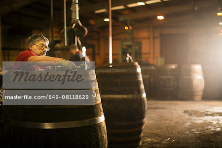 Mature man making whisky cask in cooperage