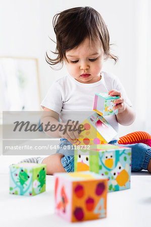 Baby boy playing on floor with toy bricks