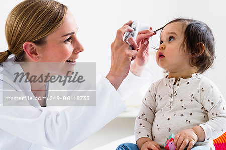 Paediatrician checking baby boy's eyes