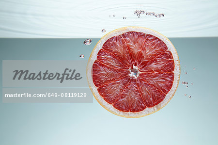 Slice of pink grapefruit underwater