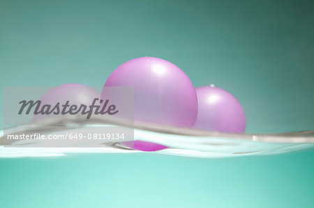 Pink balloons floating on water surface Pink balloons floating on water surface